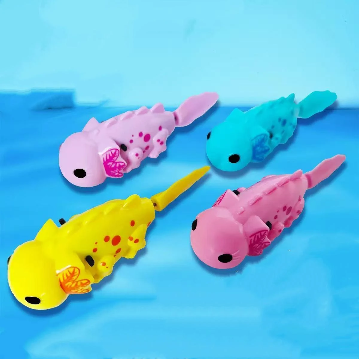 Purple, turquoise, yellow and pink axolotl-shaped battery-operated toy fish on a blue background.